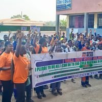 School children taking a snapshot with a banner
